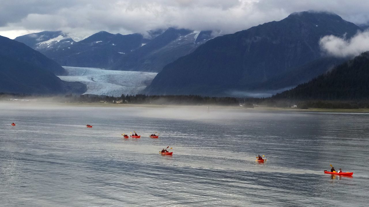 Alaska's state capital, Juneau, lies between sea and mountains and is a jumping-off point for exploring both. These kayakers are navigating waters off Douglas Island. In the distance, the 13-mile long Mendenhall Glacier is a popular hiking destination.