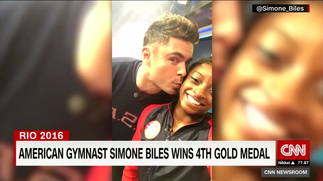 Zac Efron plants a kiss on Simone Biles' cheek.