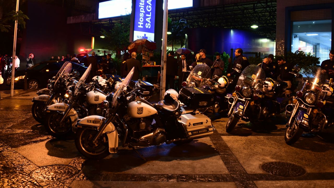Police wait outside a hospital to hear news about a colleague who was shot in a Rio slum on August 10.