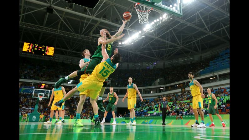 Antanas Kavaliauskas of Lithuania makes a layup over Australia's Damian Martin during a quarterfinal game. Australia won 90-64.