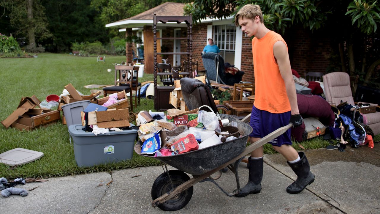 Kade Lewis helps gut his grandparents' home in Walker on Wednesday, August 17, after flooding.
