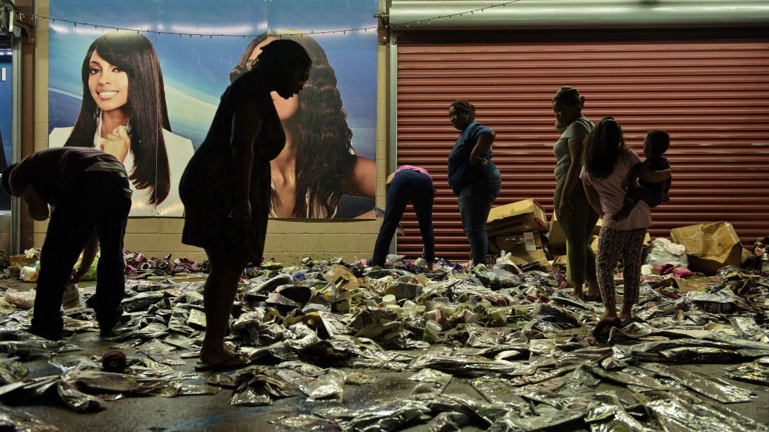 People sort through water-damaged products outside Jasmine's Beauty Supply in Baton Rouge on August 16.