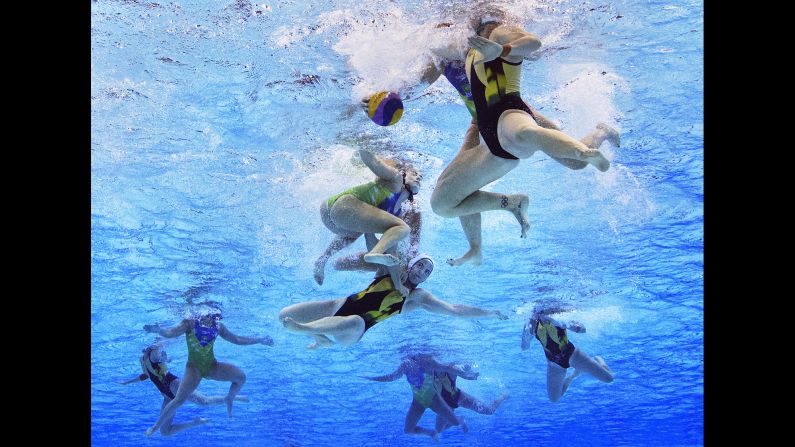 Water polo players from Australia and Brazil tussle underwater.