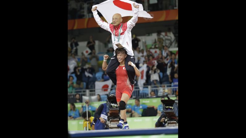 Another Japanese wrestler, Eri Tosaka, carries her coach on her shoulders after winning gold in her weight class.