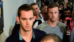 American swimmers Gunnar Bentz (L) and Jack Conger leave the police station at the Rio de Janeiro International Airport after being detained on the plane that would travel back to the US.  
Brazilian police arrested two US swimmers and a top International Olympic Committee official as scandal overshadowed the Rio Games and Usain Bolt's progress toward a new gold.  Jack Conger and Gunnar Bentz were taken off a flight leaving Rio de Janeiro by authorities investigating doubts over their claim to have been mugged. / AFP / TASSO MARCELO        (Photo credit should read TASSO MARCELO/AFP/Getty Images)