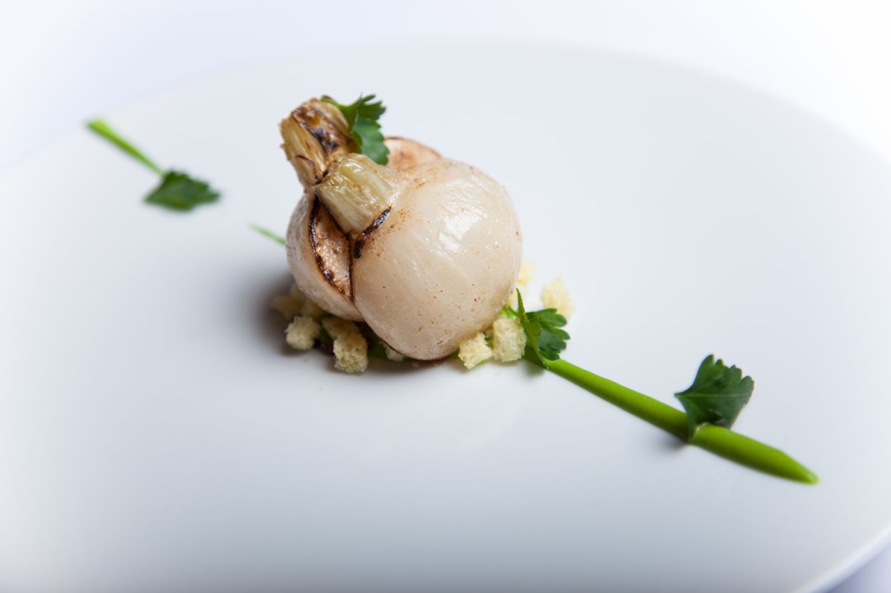 Whole-cooked turnip with parsley oil emulsion, Kintoa Basque ham and brioche is a signature dish at L'effervescence.