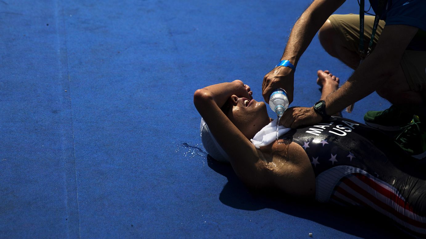 U.S. triathlete Joe Maloy is doused with water after crossing the finish line.