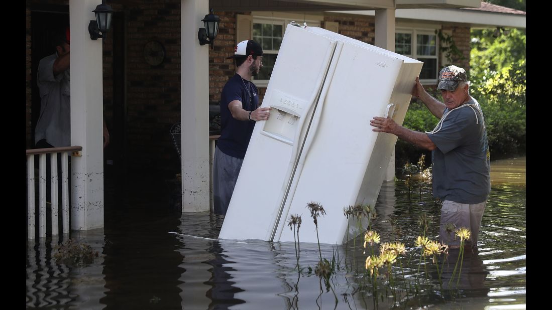 Baron Leblanc, left, and George Snyder move a refrigerator out of George's flooded home in St. Amant on Thursday, August 18. More than 30,000 people have been rescued in southern Louisiana after heavy rains caused flooding. "This is a major disaster," Louisiana Gov. John Bel Edwards has said.