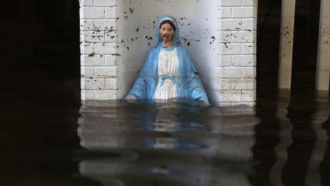A Virgin Mary statue is barely visible in front of a flooded home in St. Amant on August 18.