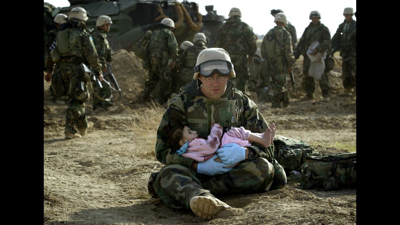 <strong>2003: Central Iraq</strong> -- A U.S. Navy hospital corpsman holds an Iraqi boy. Confused front-line crossfire ripped apart an Iraqi family. This moment of compassion was captured barely a year after the official start of the U.S.-led war in Iraq. 