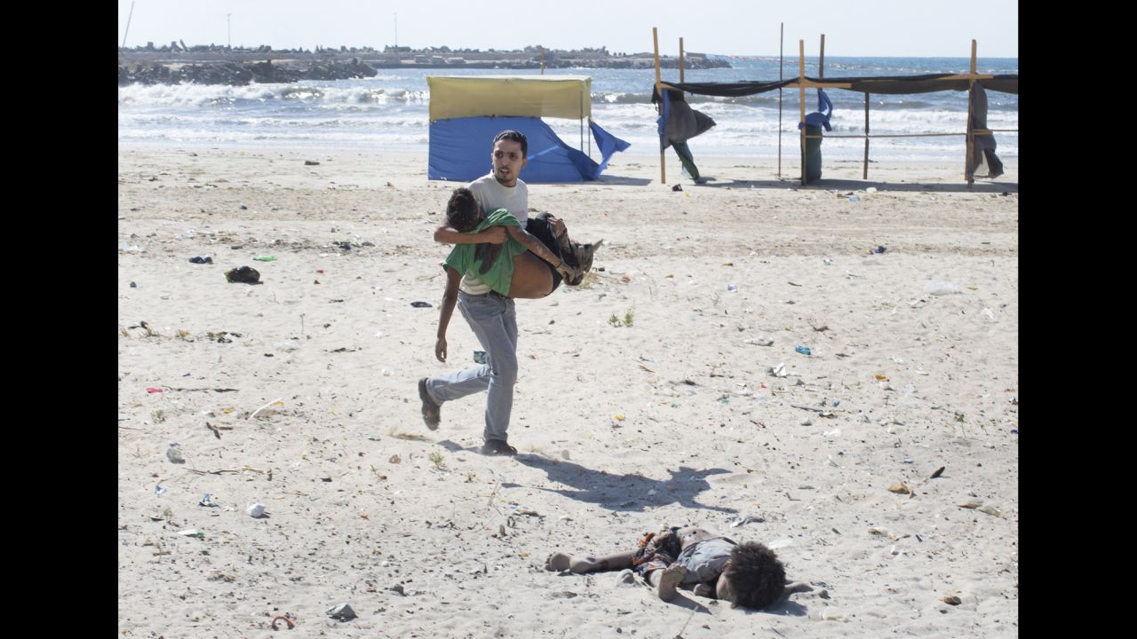 <strong>2014: Gaza City </strong>-- A man carries a child as another lies dead after an Israeli airstrike on a Gaza City beach in July 2014. At least four boys, ages 9 to 11, were killed. The Israeli military investigated the tragedy and reported that the location of the attack was known to be a compound of Hamas police and naval forces. "Tragically, in the wake of the incident it became clear that the outcome of the attack was the death of four children who had entered the military compound for reasons that remain unclear," <a href="http://www.cnn.com/2015/06/11/middleeast/israel-gaza-beach-bombing/" target="_blank">the report stated.</a>