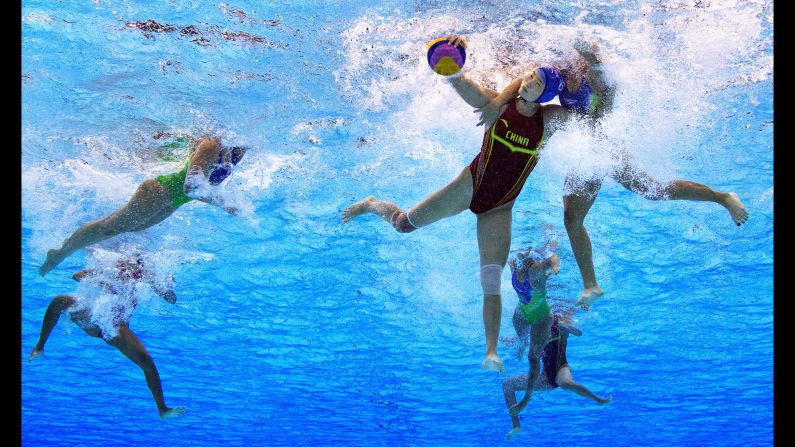 Sun Yating of China is challenged by a Brazilian player in a water polo match.