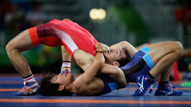 Japanese freestyle wrestler Sosuke Takatani, in blue, competes against France's Zelimkhan Khadjiev.