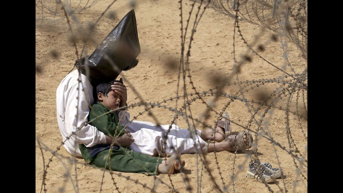 <strong>2003: Najaf, Iraq </strong>-- An Iraqi prisoner of war comforts his son in a POW holding zone. The emotional image won the 2003 World Press Photo award. 