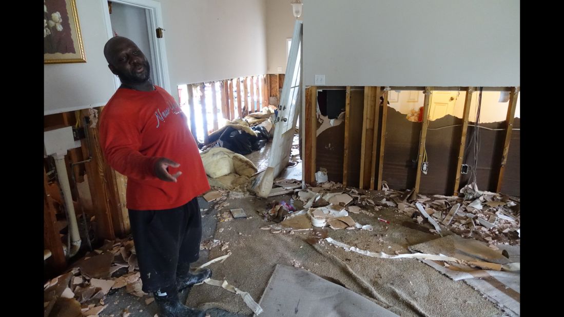 Laytrom Rheams wears muck boots as he works to gut his home of eight years because a quarter-inch of water remained in his carpet almost a week after the historic flooding began. One of his first orders of business: remove the sheet rock so he can treat his home's beams in hopes of combating mold. 