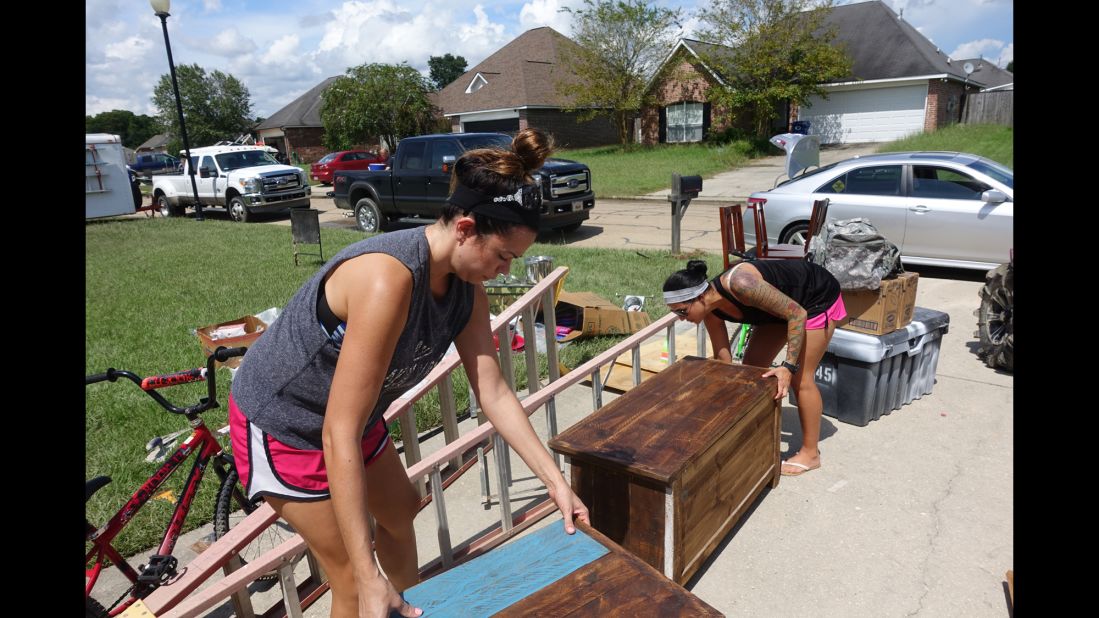 Owens' roommate, Staff Sgt. Pamela Vance, right, and her sister, Jennifer, carry some of Vance's and Owens' prized furniture pieces out of their home. Vance hails from Slidell, Louisiana, and was a victim of Hurricane Katrina. She likens the flooding in Denham Springs to the devastating 2005 natural disaster. "All these emotions run through, and you say: 'God, why? Again? Everything you worked for?' "