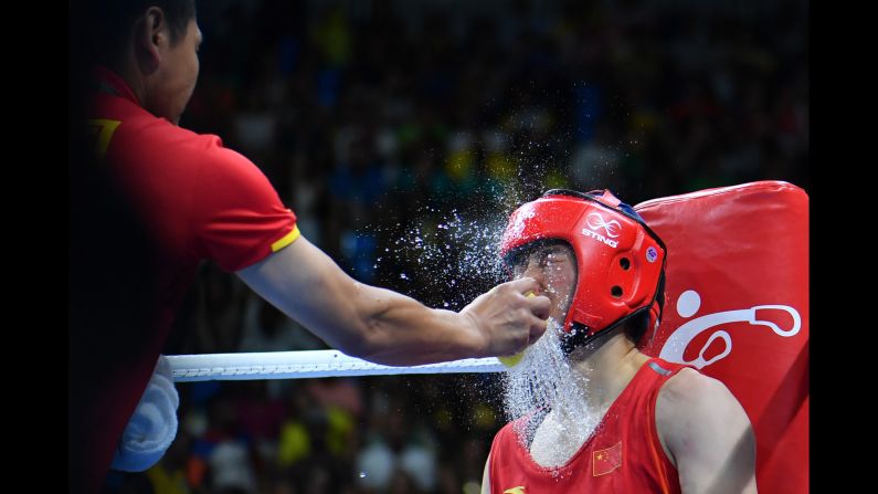 Water is splashed onto Chinese middleweight boxer Li Qian between rounds of her semifinal bout against the Netherlands' Nouchka Fontijn.