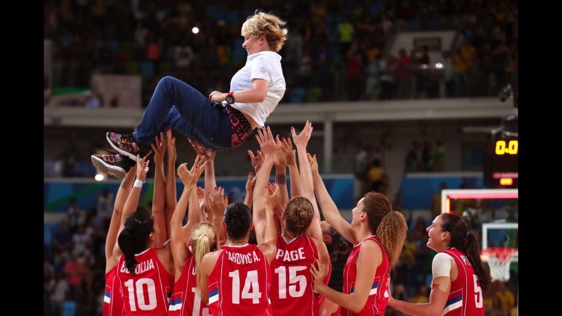 The Serbian basketball team celebrates with their coach, Marina Maljkovic, after defeating France 70-63 in the bronze medal match.