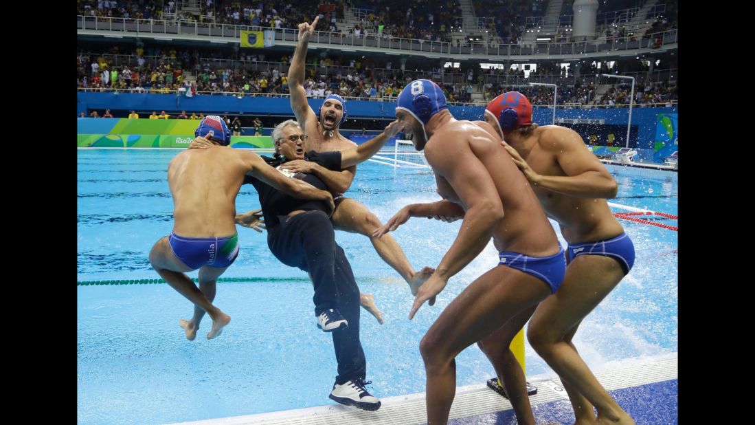 Italian water polo players celebrate with their coach Alessandro Campagna after defeating Montenegro in the bronze medal game.