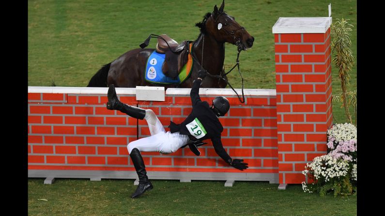 Jan Kuf of the Czech Republic falls from his horse in the show jumping portion of the modern pentathlon.