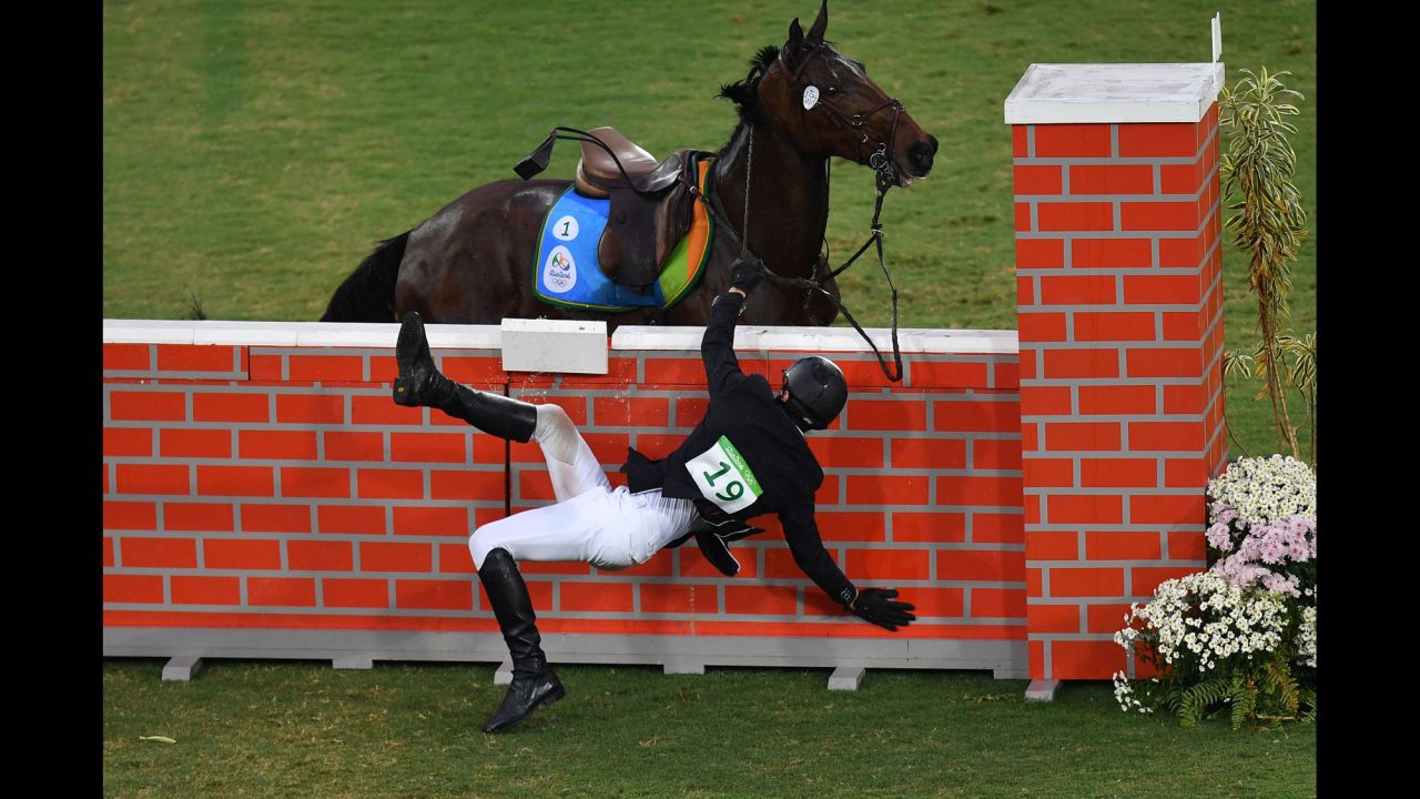 Jan Kuf of the Czech Republic falls from his horse in the show jumping portion of the modern pentathlon.
