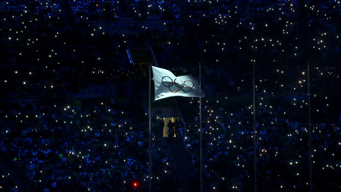 The International Olympic Committee flag waves in the stadium.