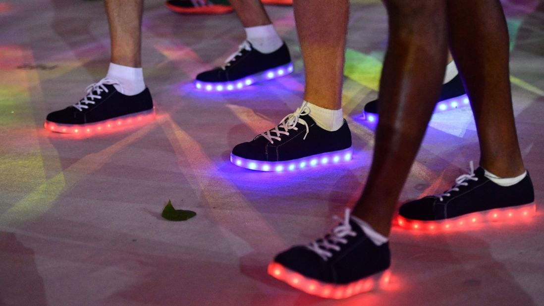 Athletes wearing illuminated shoes march during the closing ceremony.