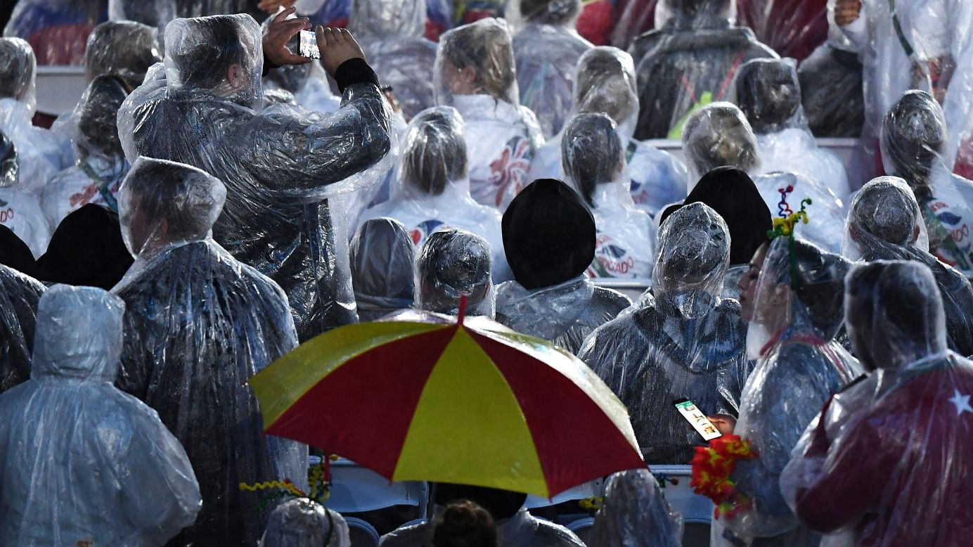 Athletes shield themselves from the rain.