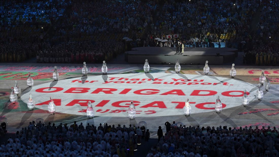 The words "thank you" are projected in Portuguese and Japanese.