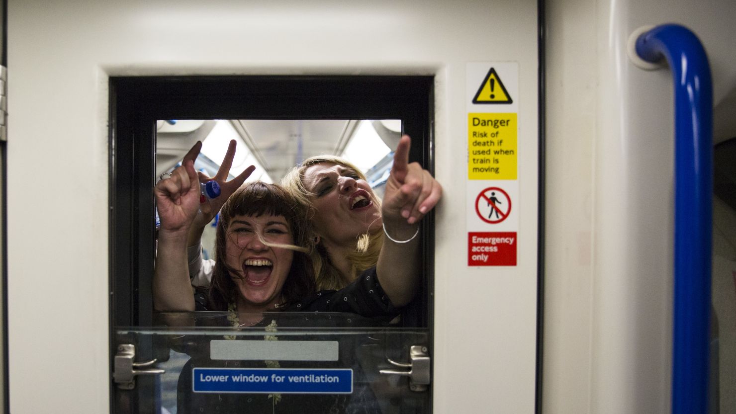 Passengers on board the Night Tube wave and cheer through a window in a carriage along the Victoria line on August 20, 2016 in London, England. 