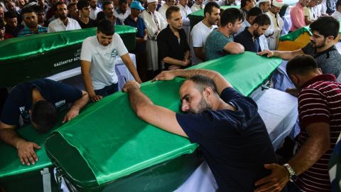 A mourner leans on a coffin at a funeral for victims of the Gaziantep blast.