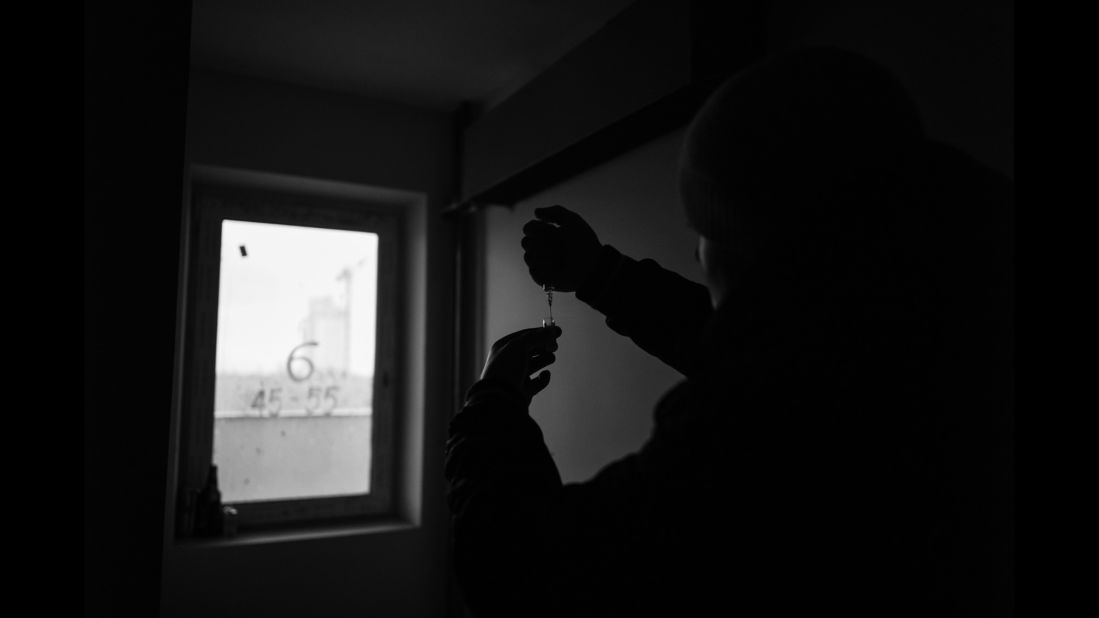 Roman prepares his methadone inside an unused building in Kiev, Ukraine. The 17th floor is a secret spot where drug users can shoot up.