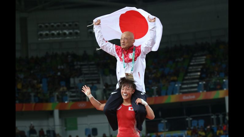 Japanese freestyle wrestler Eri Tosaka carries her coach on her shoulders after winning gold in her weight class on Wednesday, August 17.