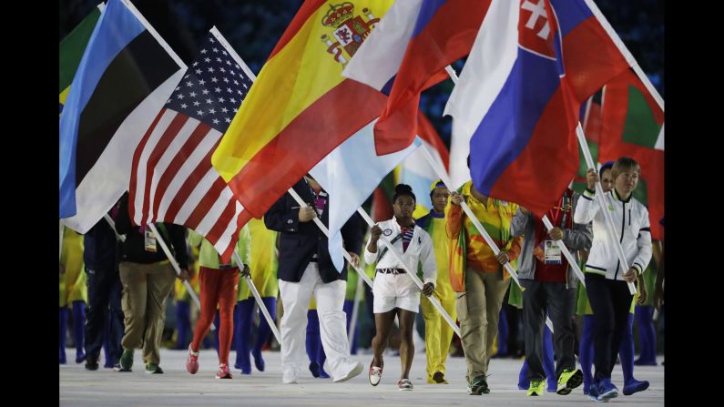 Gymnast <a href="index.php?page=&url=http%3A%2F%2Fwww.cnn.com%2F2016%2F08%2F20%2Fhealth%2Fsimone-biles-role-model-cliff-jumper%2F" target="_blank">Simone Biles</a>, in the white shorts, carries the American flag during the closing ceremony on Sunday, August 21. Biles, who won gold in both the individual and team all-around, became the first American gymnast to win four gold medals in a single Olympics.