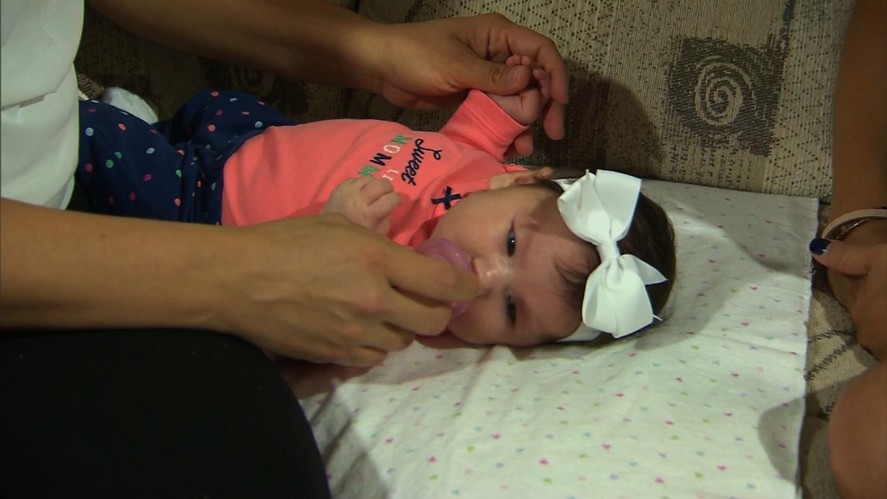 Maria Mendoza massages her daughter Micaela's hands during a session of occupational therapy.