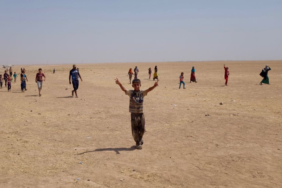 Refugee camps outside al-Qayyara, Iraq, where people live in hostile conditions, with scorching desert winds and constant heat.