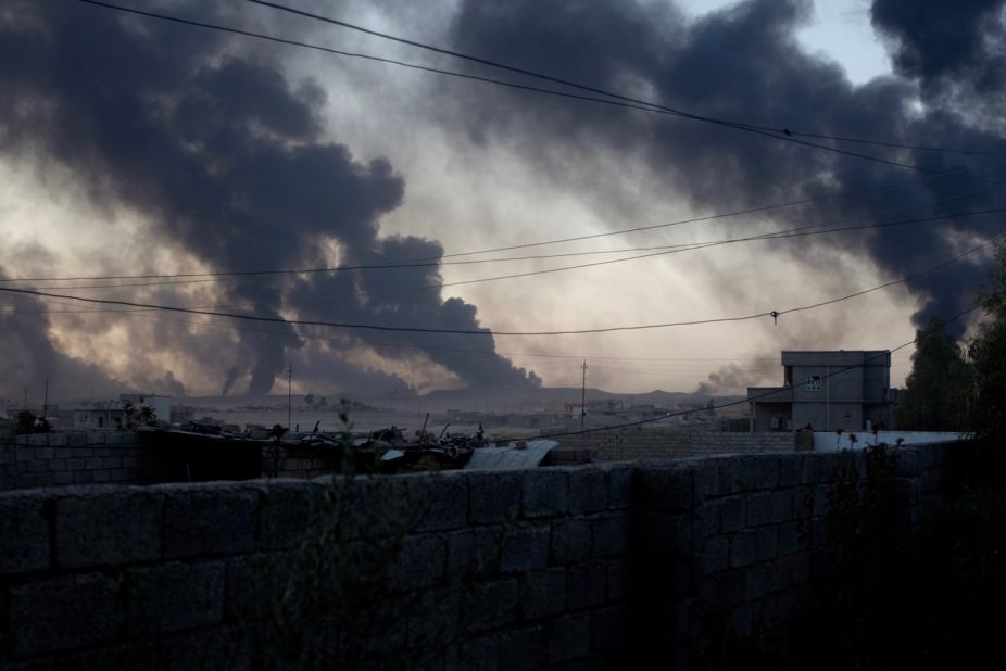 Smoke rises from al-Qayyara in the late afternoon light, as ISIS burns crude oil to block visibility from above.