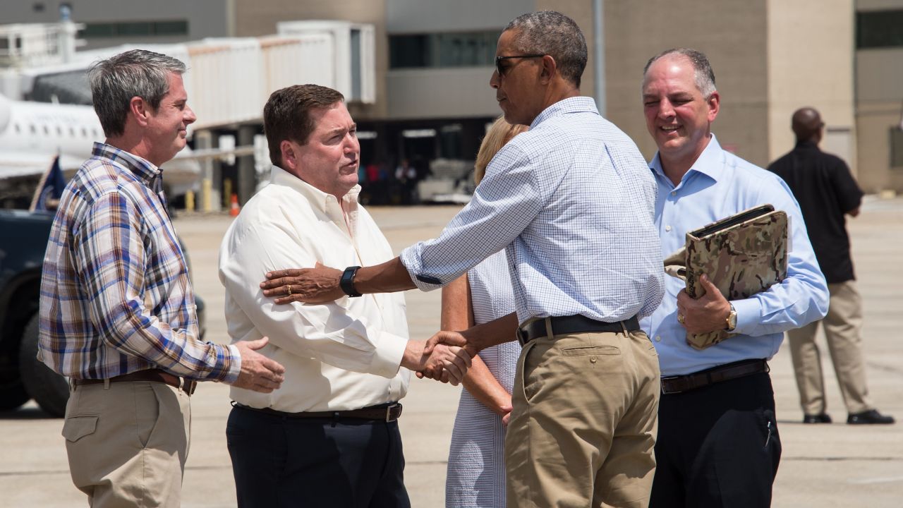 President Barack Obama is greeted by Louisiana Lt. Gov. Billy Nungesser as Gov. John Bel Edwards, right, his wife, Donna, and Sen. David Vitter, left, look on at Baton Rouge Metropolitan Airport in Baton Rouge, Louisiana, on August 23, 2016.