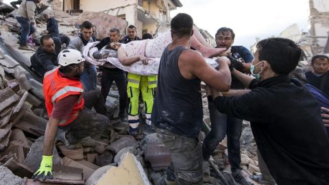 A woman is pulled from the rubble following an earthquake in Amatrice, Italy.