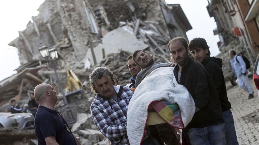 An injured man is rescued from a collapsed building in Amatrice on August 24.