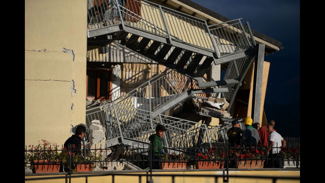 Residents survey a collapsed staircase in Amatrice on August 24.