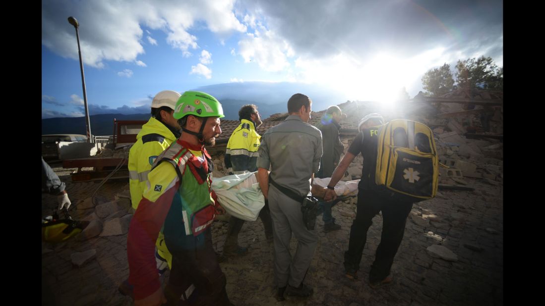 Rescuers carry a man through earthquake debris in Amatrice.