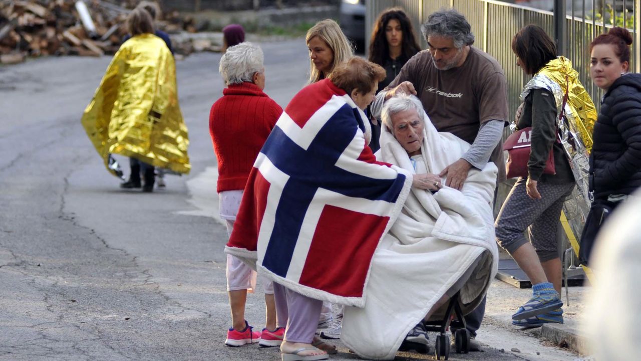 Residents of Pescara del Tronto care for an elderly earthquake victim on August 24.