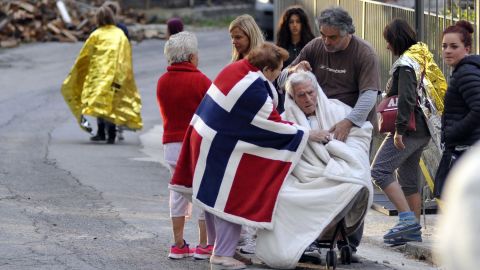 Residents of Pescara del Tronto care for an elderly earthquake victim on August 24.