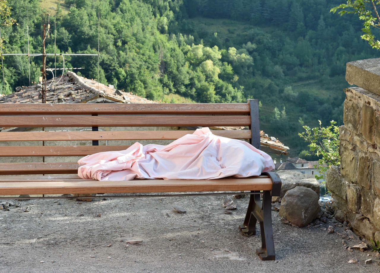 The body of a unidentified child lies on a bench in Arquata del Tronto on August 24.