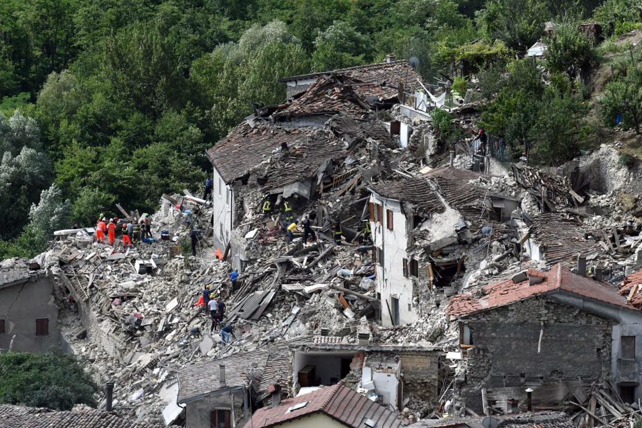 Search-and-rescue teams survey collapsed houses in Pescara del Tronto on August 24.
