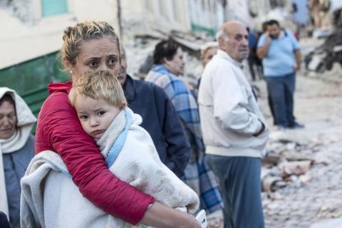 A woman tries to comfort her child in Amatrice on August 24.