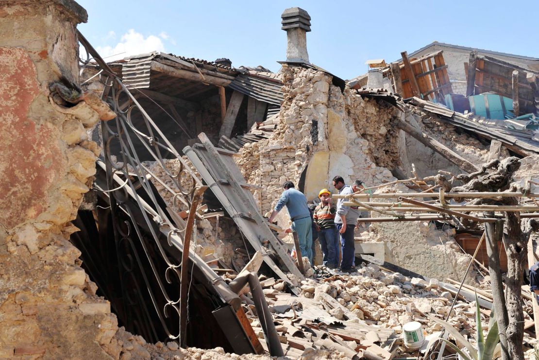 Residents inspect the rubble of buildings destroyed by an earthquake on April 6, 2009 in Onna, Italy. 