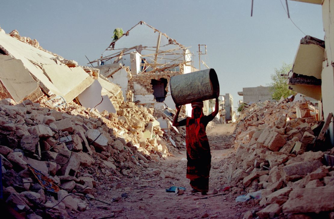 A woman walks to her tent on the outskirts of Bhuj, India, after an earthquake left tens of thousands homeless.