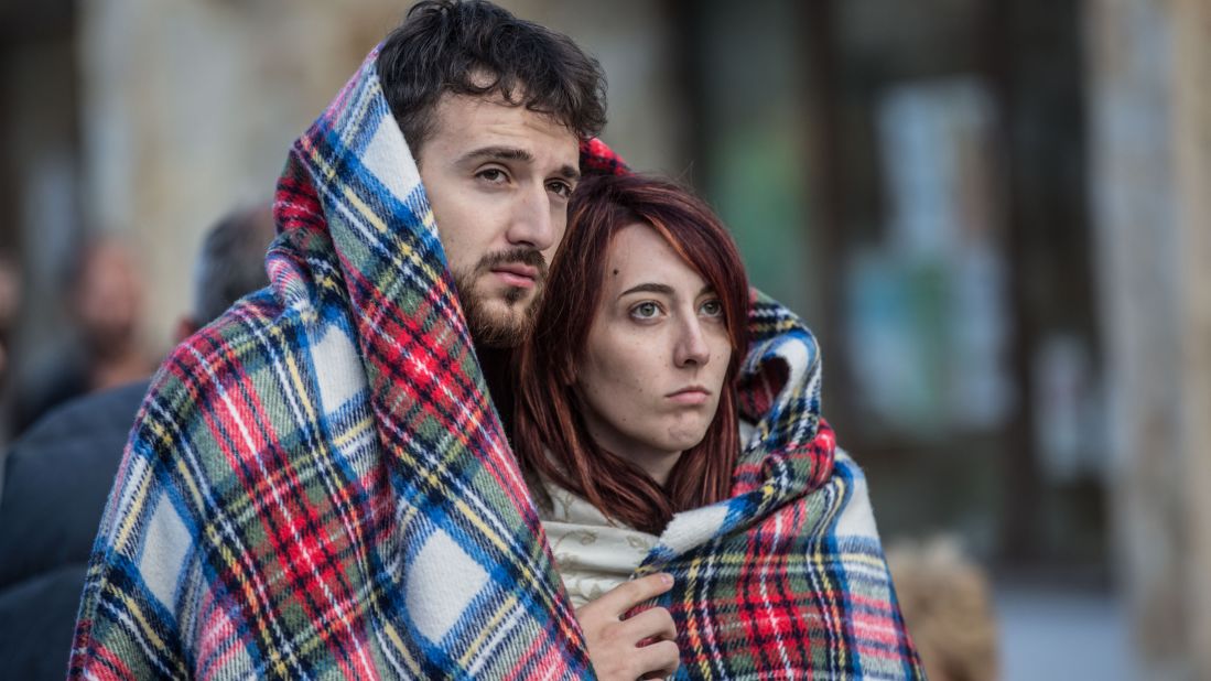 Two people huddle together in Amatrice after the earthquake. 